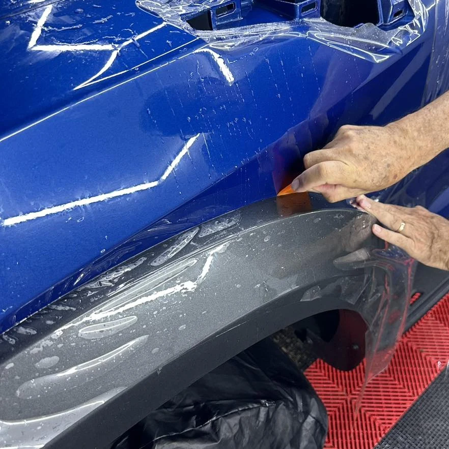 Instalación de película PPF sobre un vehículo azul